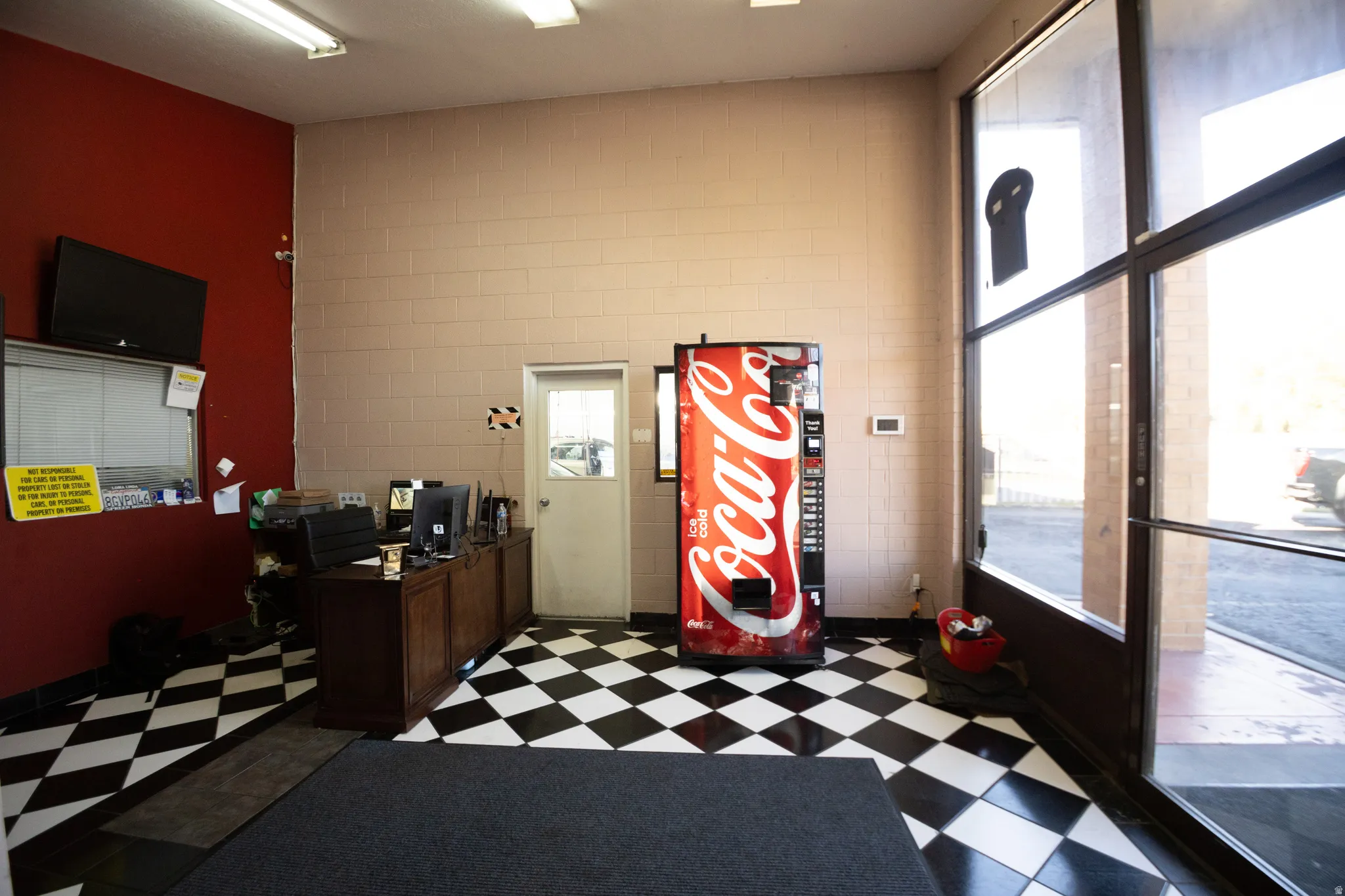 Spacious commercial interior featuring black and white checkerboard flooring