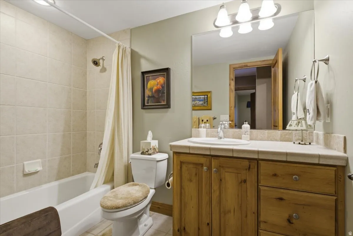 Bathroom featuring a light-toned tile shower surround with a white tub