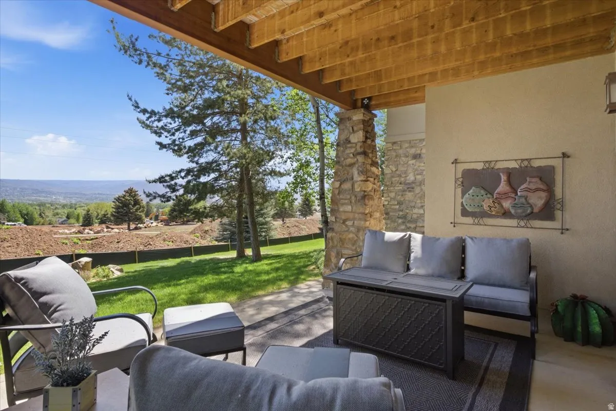 Covered patio featuring views of the golf course and a gas fire pit
