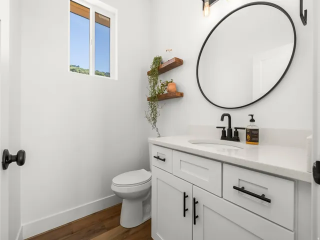 Modern bathroom featuring a white vanity with shaker-style cabinetry, a built-in sink, and a light-toned countertop