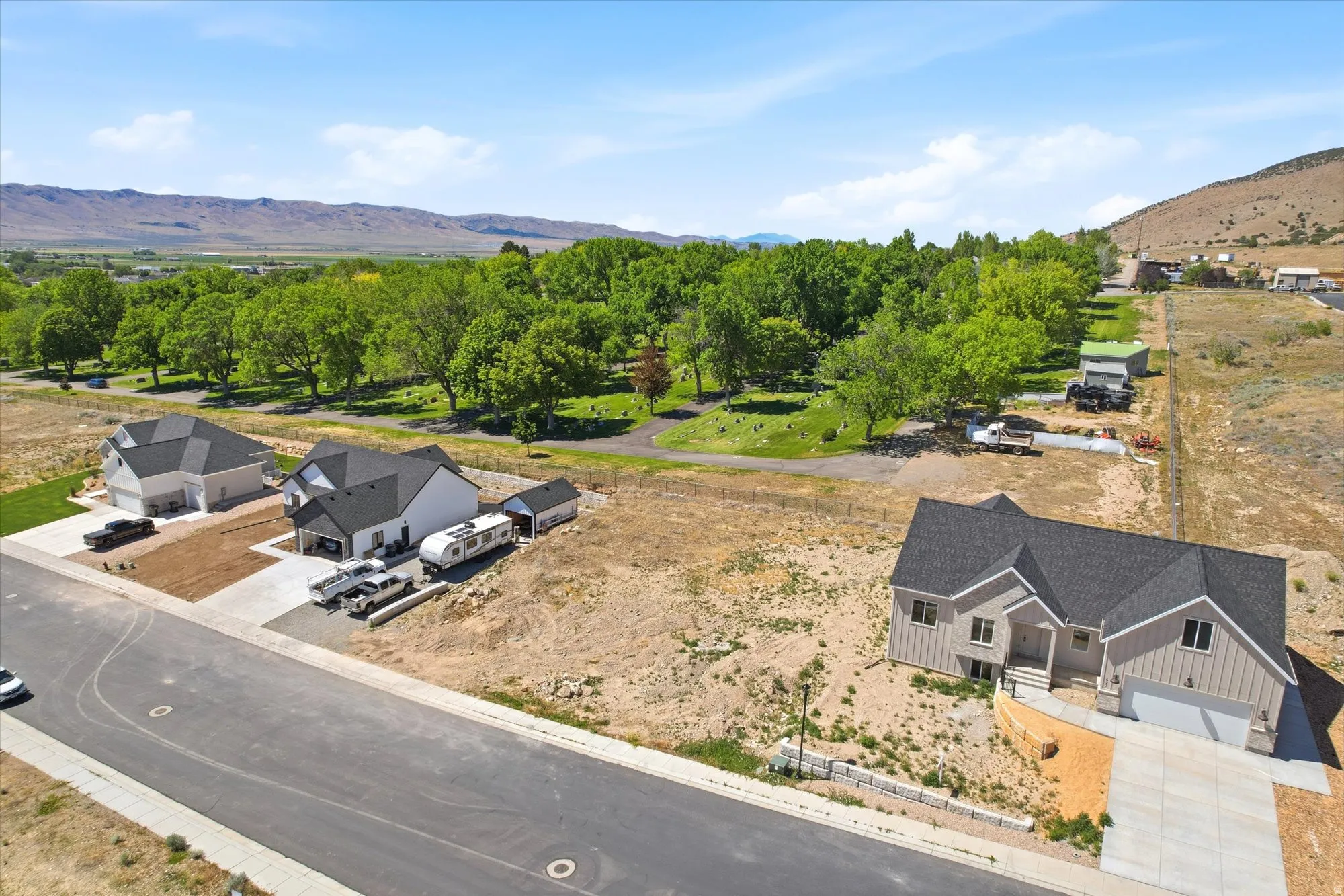 Newly constructed residence featuring a gray exterior with vertical siding, dark roof, two-car garage, and concrete driveway