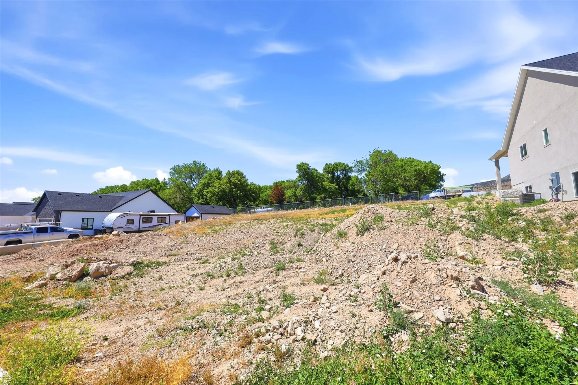 Expansive undeveloped lot featuring varied terrain and partial fencing