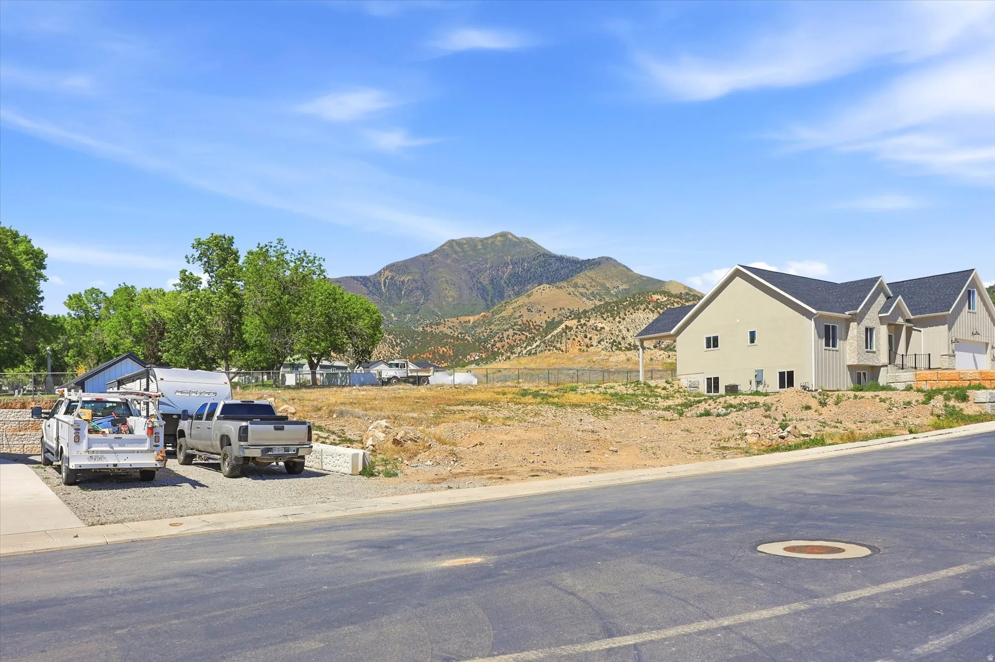 Expansive building lot featuring mountain scenery and a partially constructed residence
