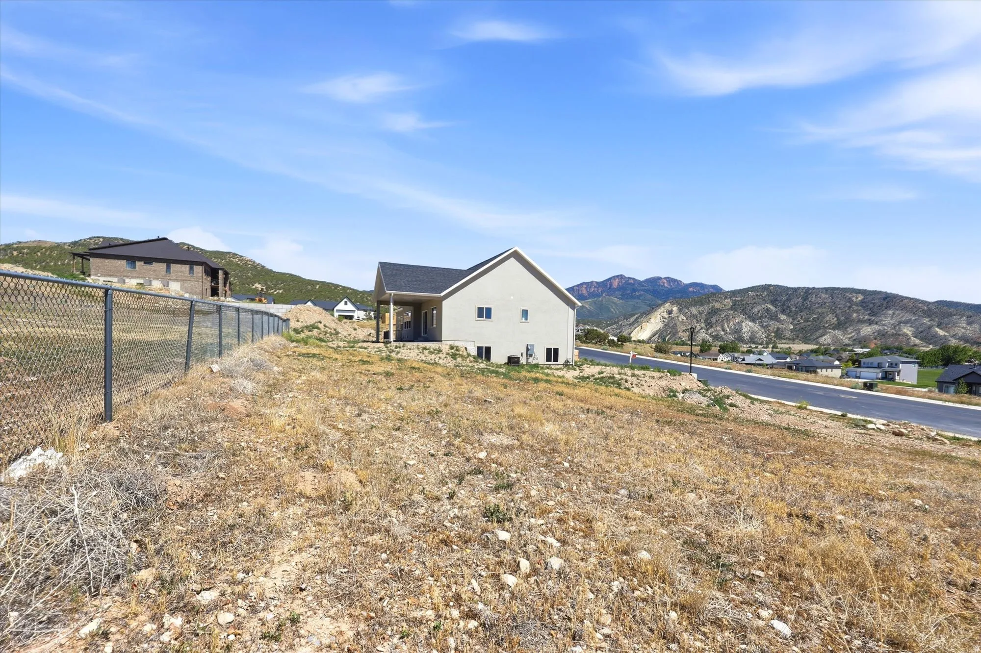 Contemporary two-story residence with a covered patio and a chain-link fence bordering the property