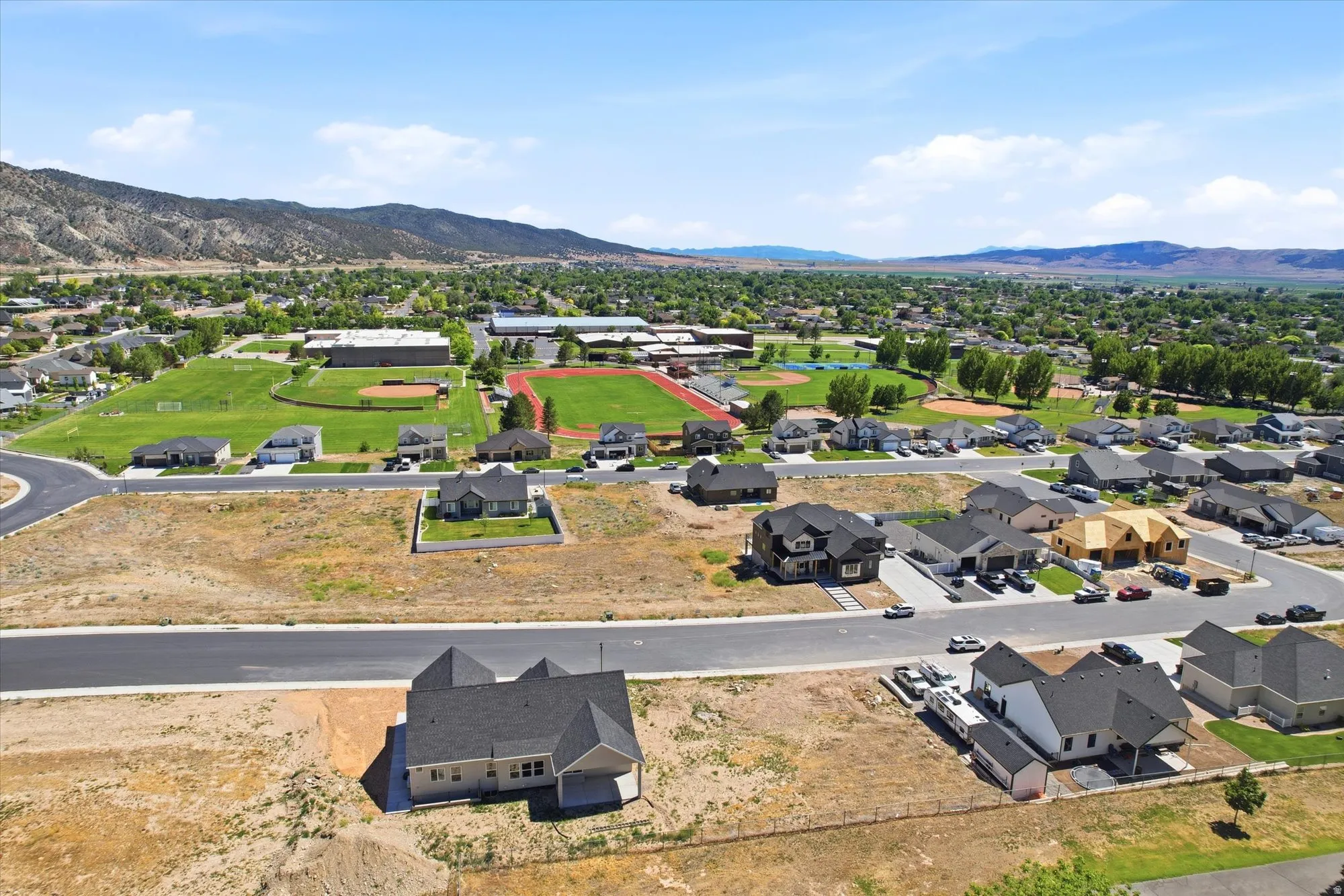 Expansive suburban development with new construction residential properties and mountain backdrops