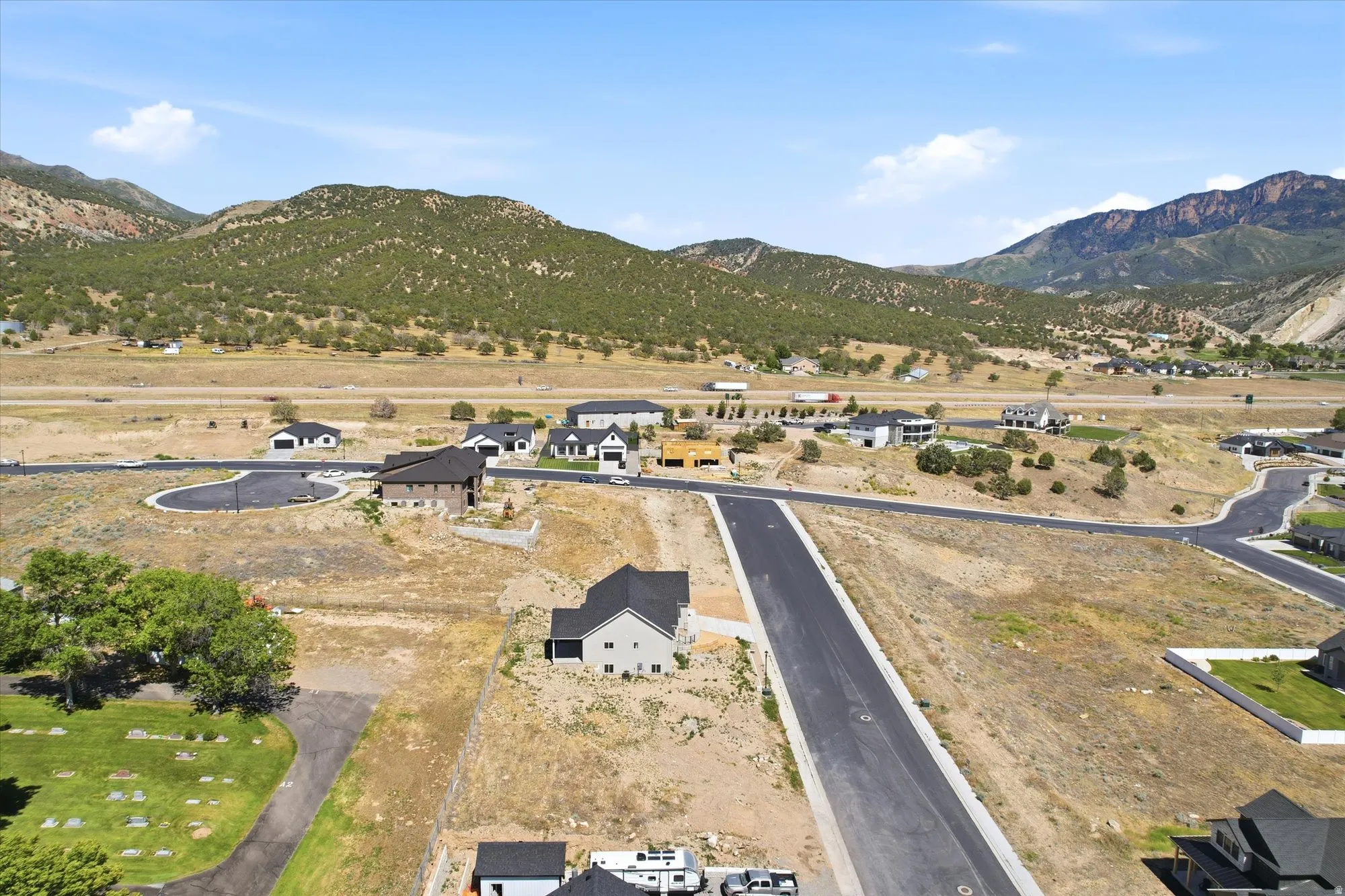Developing residential area with paved streets, surrounded by arid landscape and distant mountains