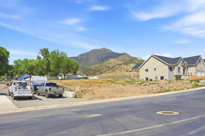Expansive building lot featuring mountain scenery and a partially constructed residence