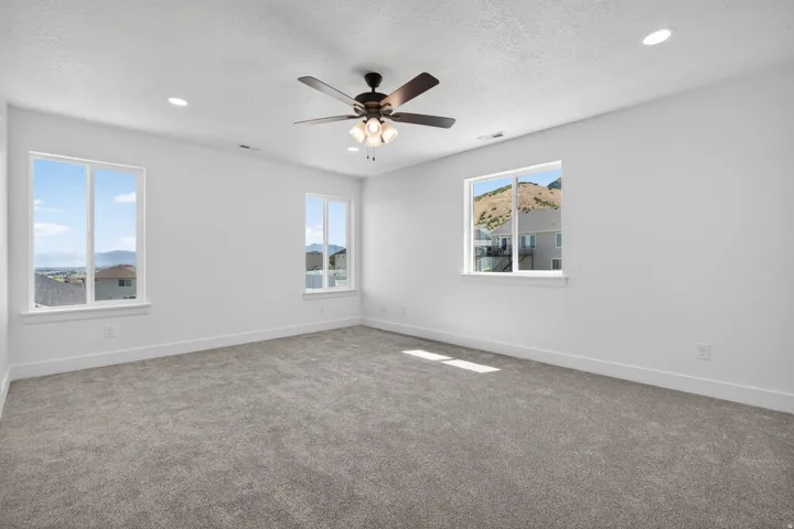Spacious room featuring light gray carpet flooring and white walls