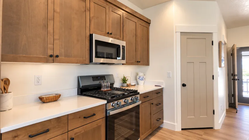 Wood-finish cabinetry paired with white countertops and stainless steel appliances