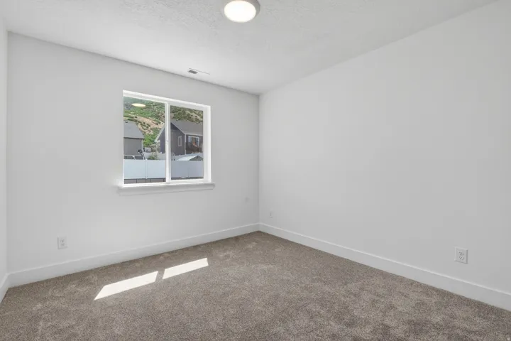 Neutral-toned carpeting complements the white walls and trim throughout this room
