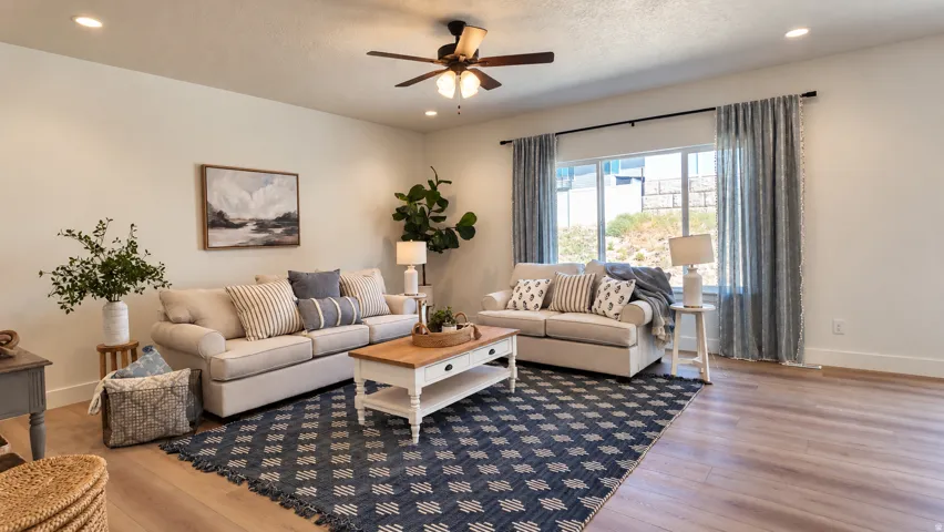 Spacious living area featuring wood-finish flooring, recessed lighting, and a ceiling fan