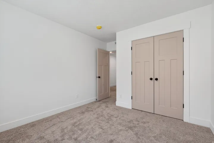 Soft-toned bifold closet doors with black hardware