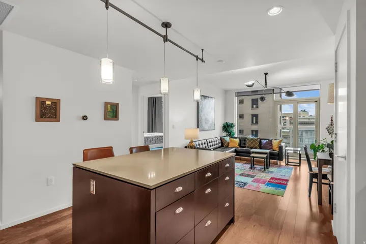 Kitchen island with an integrated breakfast bar and track pendant lighting