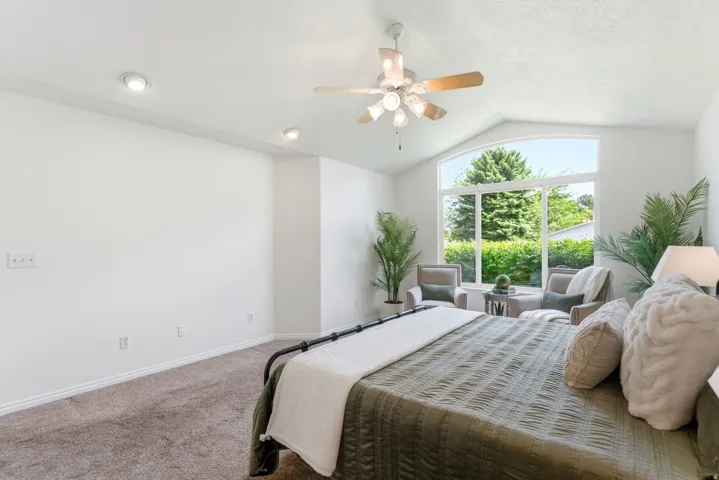 Vaulted ceiling bedroom featuring a large arched picture window