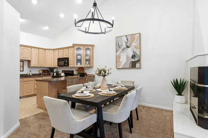 Open-concept dining area featuring a vaulted ceiling with a sputnik chandelier