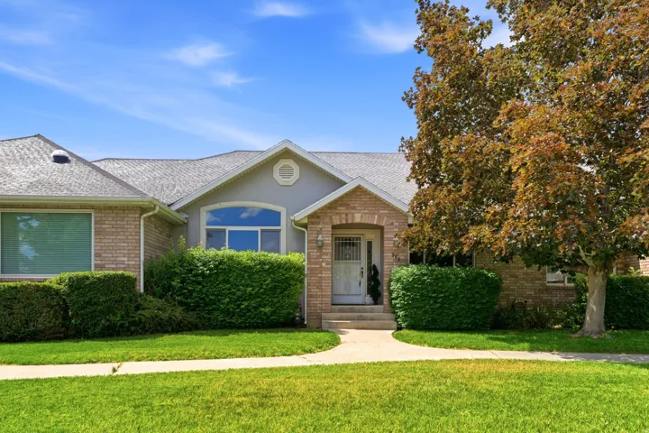 Brick and stucco exterior featuring an arched entryway with a white door