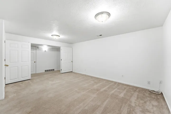 Carpeted room featuring white walls and white trim