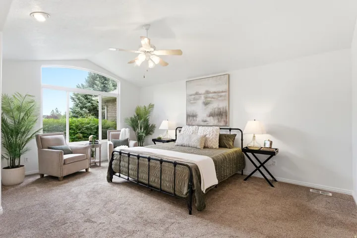 Vaulted ceiling room featuring a large arched window, recessed lighting, ceiling fan, and light-toned carpet flooring