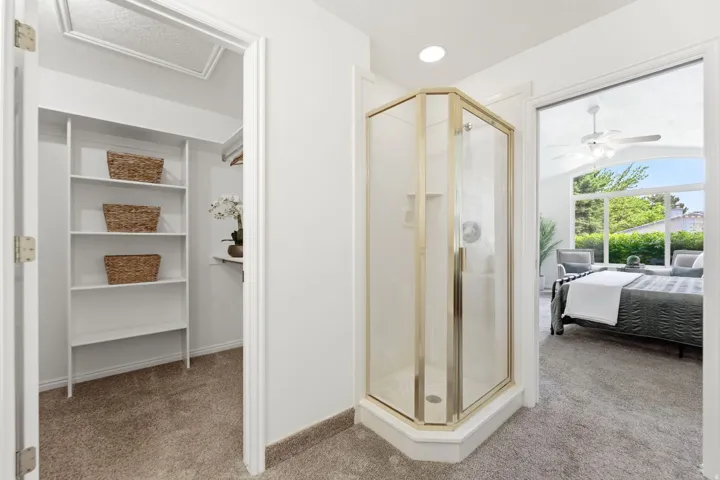 Corner shower stall featuring a gold-finish frame and clear glass enclosure