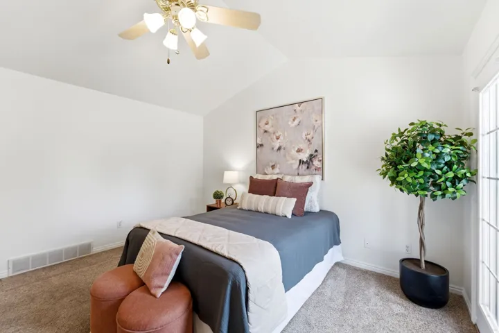 Vaulted ceiling featuring a brass-finish ceiling fan with integrated lighting