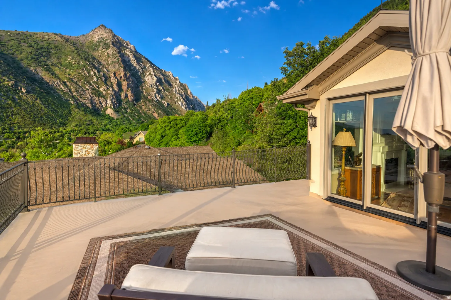 Expansive outdoor patio featuring a decorative metal railing and a large sliding glass door