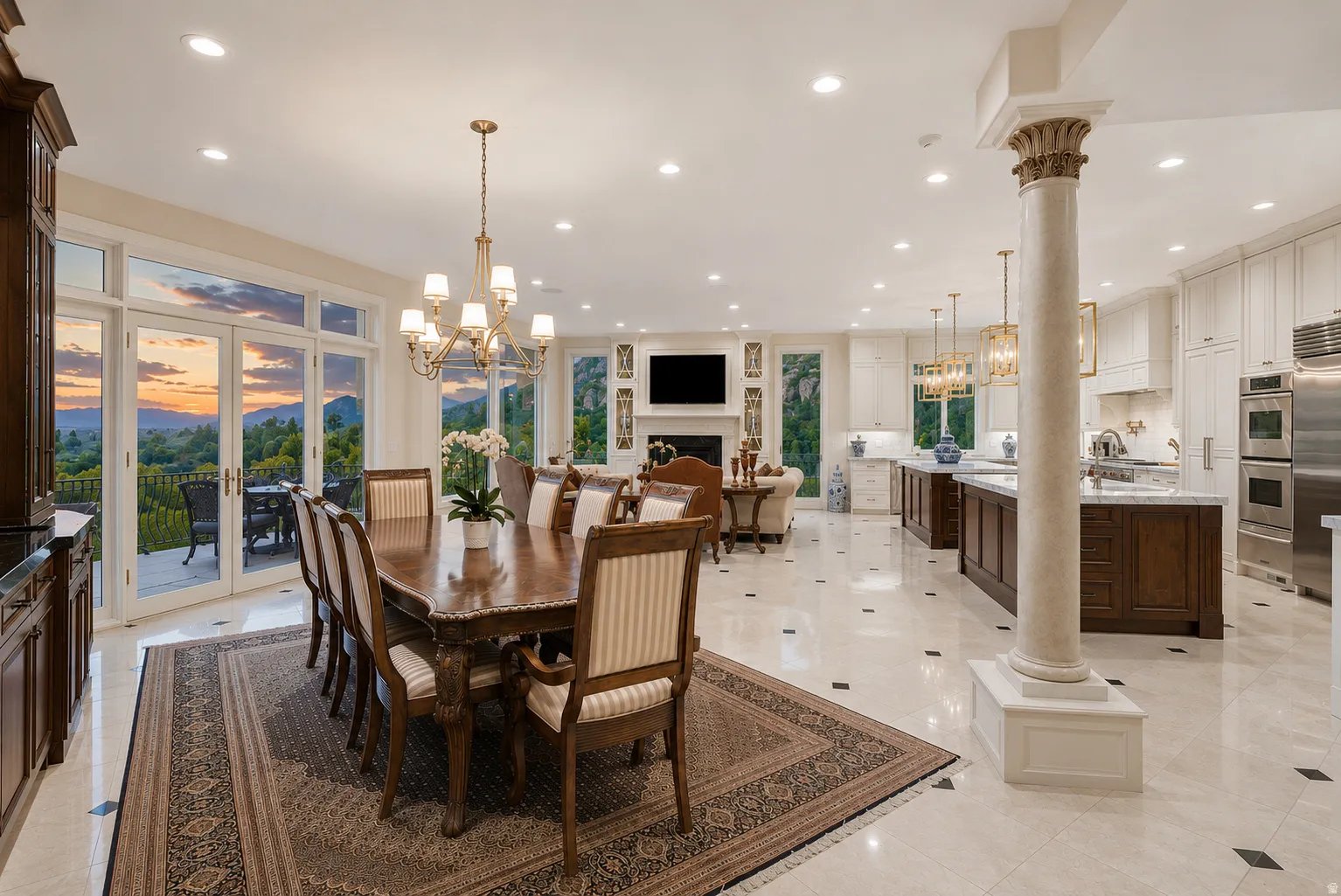 Spacious open-concept interior featuring light-toned flooring with dark accent tiles, French doors opening to an outdoor patio, a formal dining area with a brass chandelier, a gourmet kitchen with stainless steel appliances, and a classical column detail