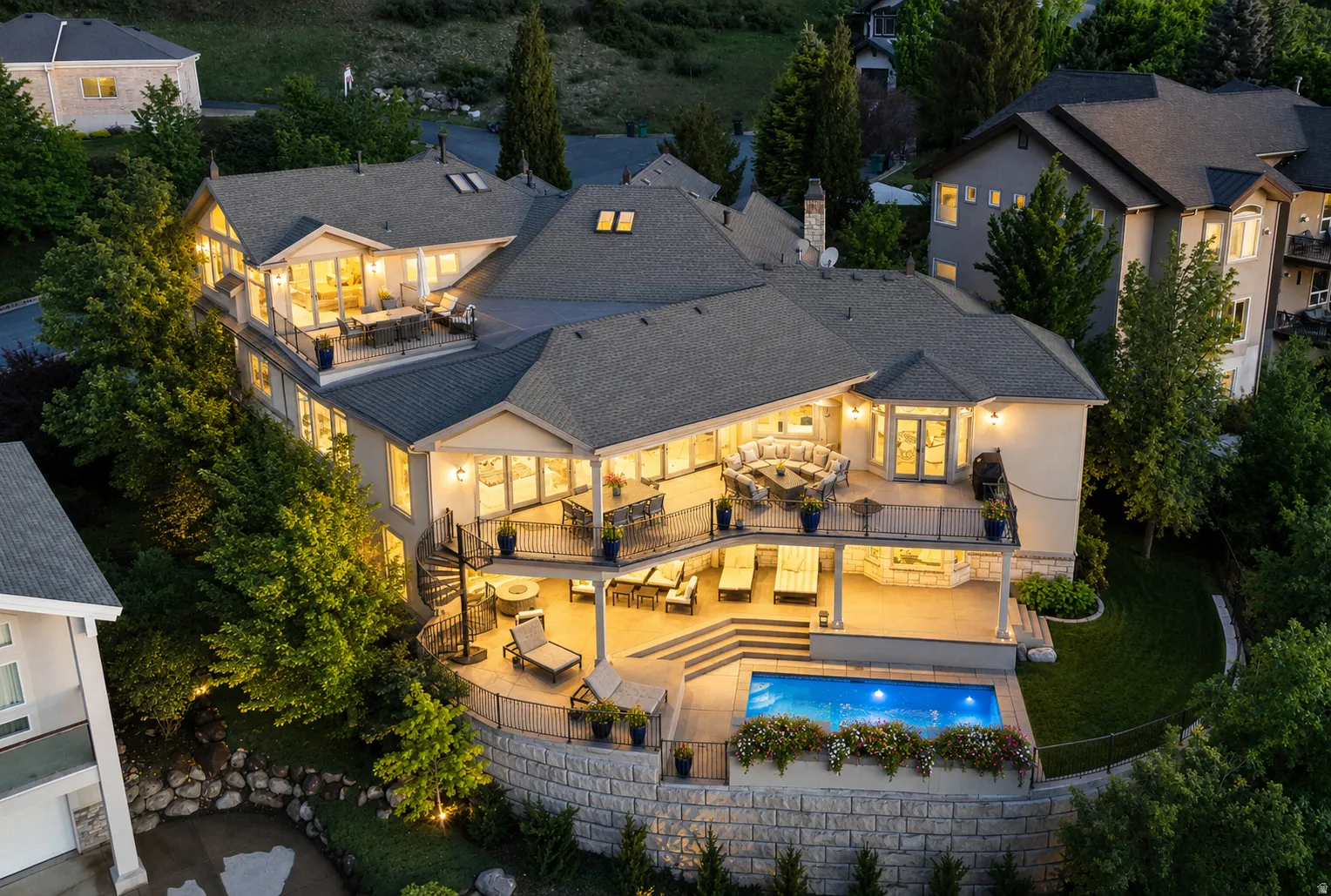 Multi-level stucco exterior featuring expansive balconies, a built-in swimming pool, spiral staircase, and terraced landscaping