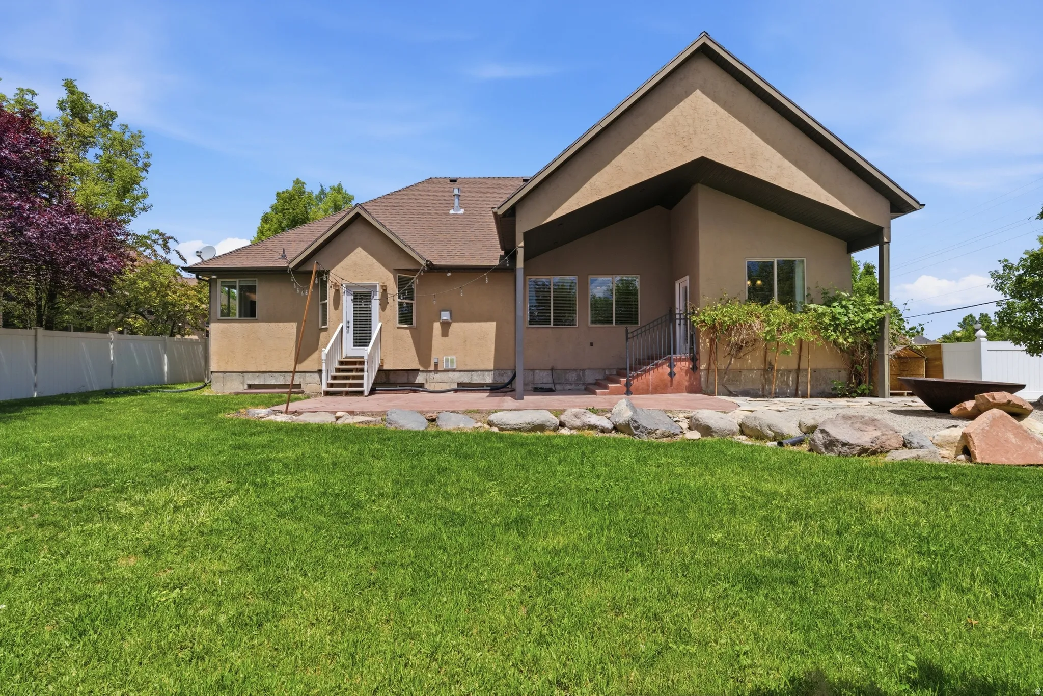 Expansive green lawn with a stucco exterior home