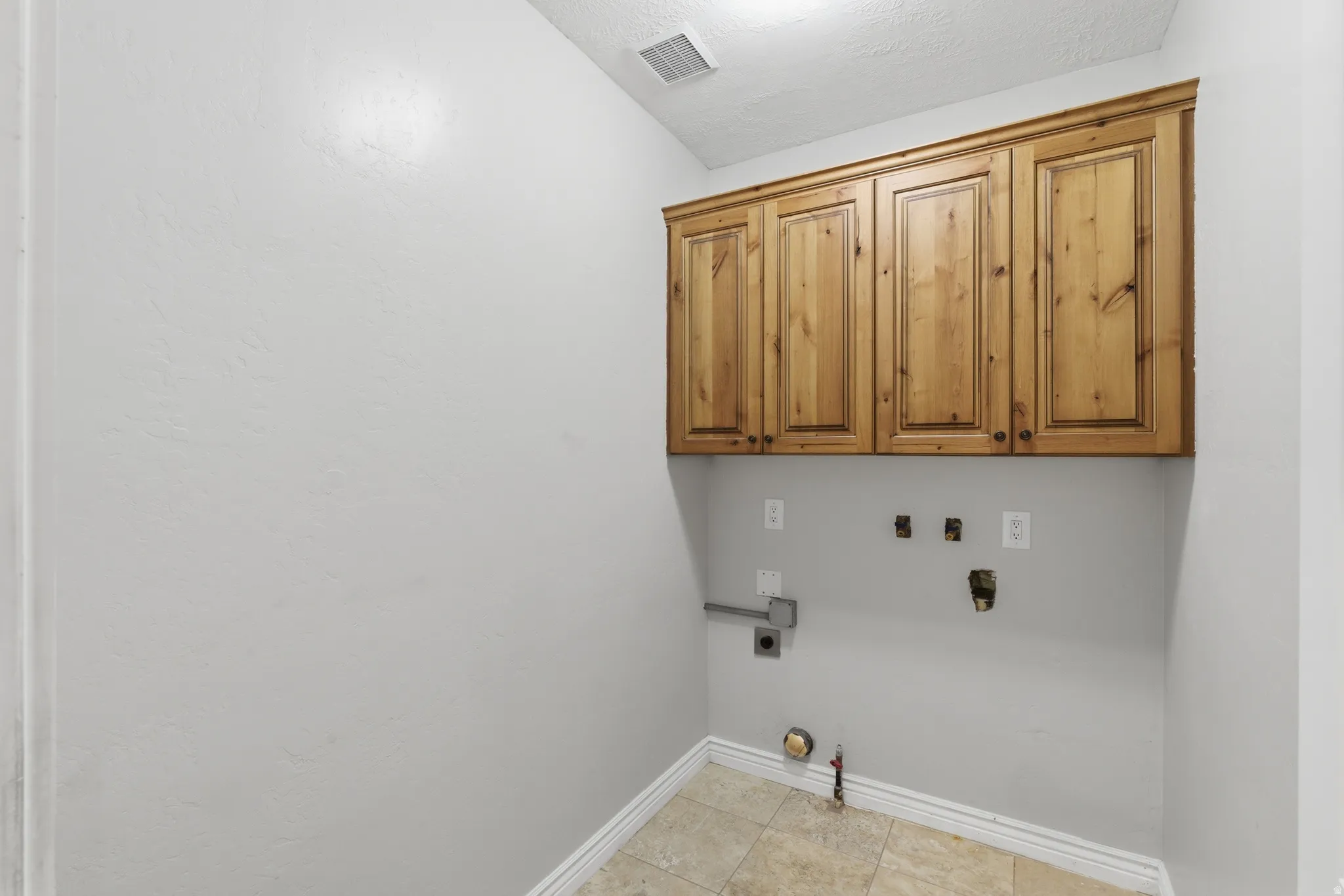 Utility area featuring natural wood cabinetry