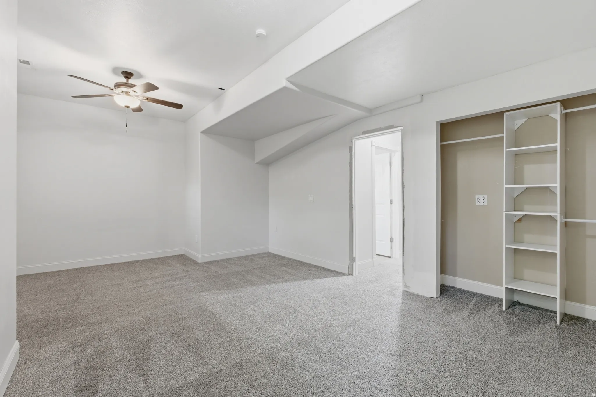 Spacious room featuring neutral carpeting and white walls