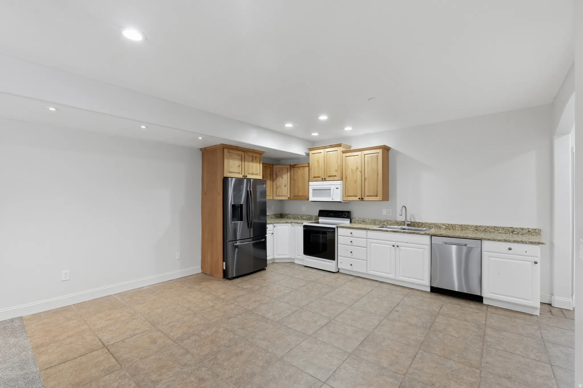 Kitchenette featuring granite-look countertops, a stainless steel refrigerator, and a stainless steel dishwasher