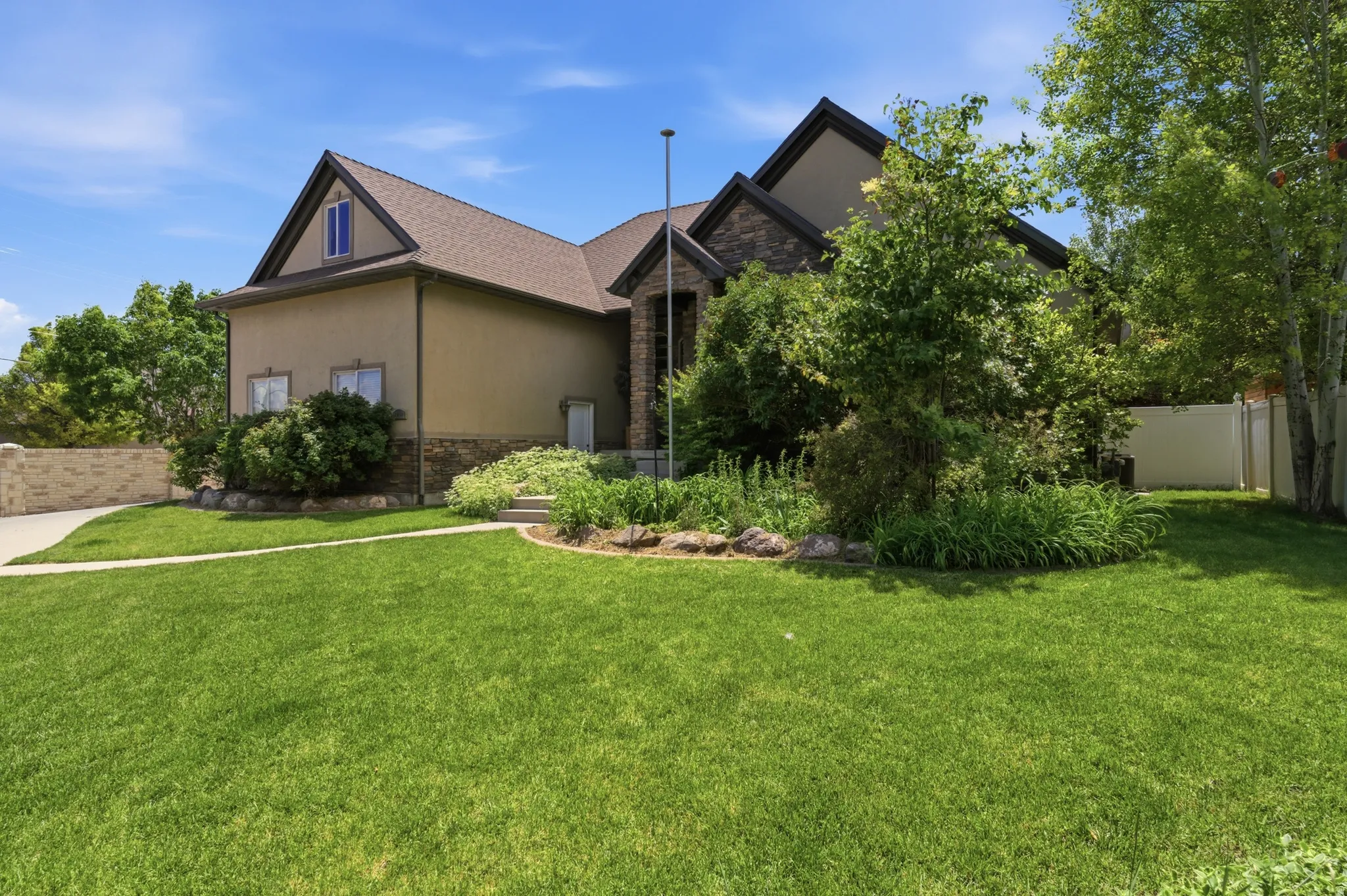 Expansive front lawn with established landscaping and mature trees