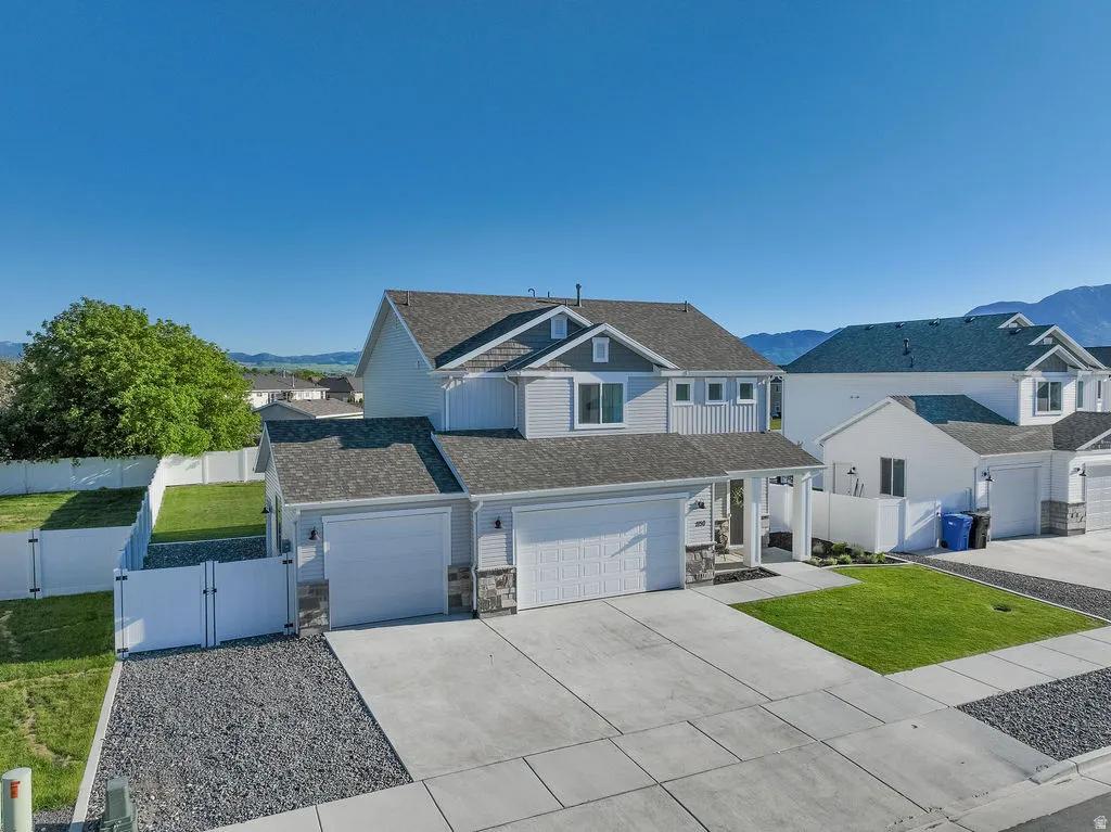 Two-story residence featuring light gray siding with stone accents