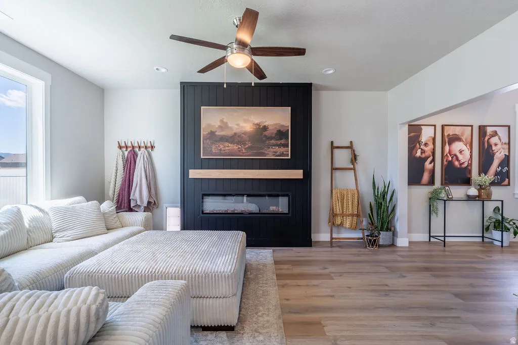 Living area featuring a floor-to-ceiling fireplace with black shiplap surround, wood mantel, and linear electric fireplace