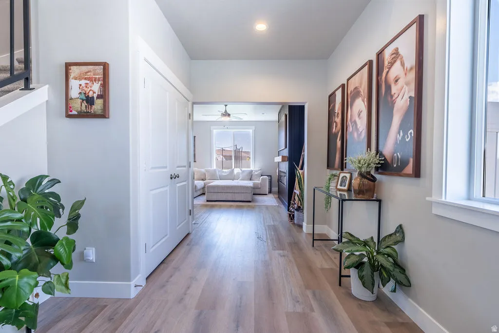 Open entryway featuring wood-finish flooring, white baseboards, and a built-in double-door closet