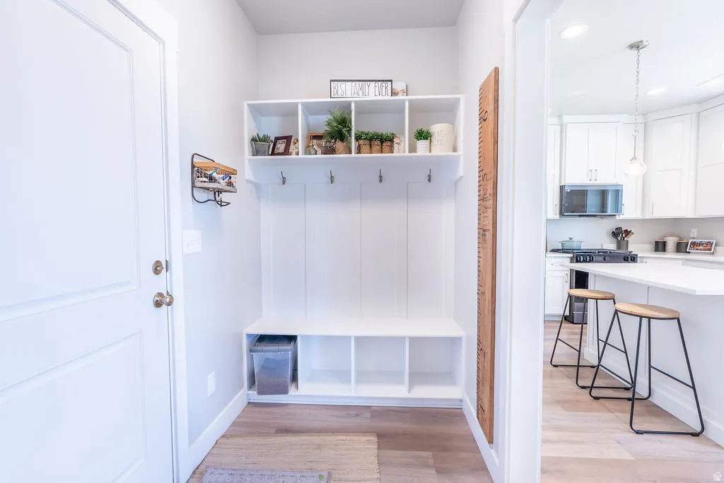 Dedicated mudroom area featuring built-in shelving, coat hooks, and bench seating with integrated storage cubbies
