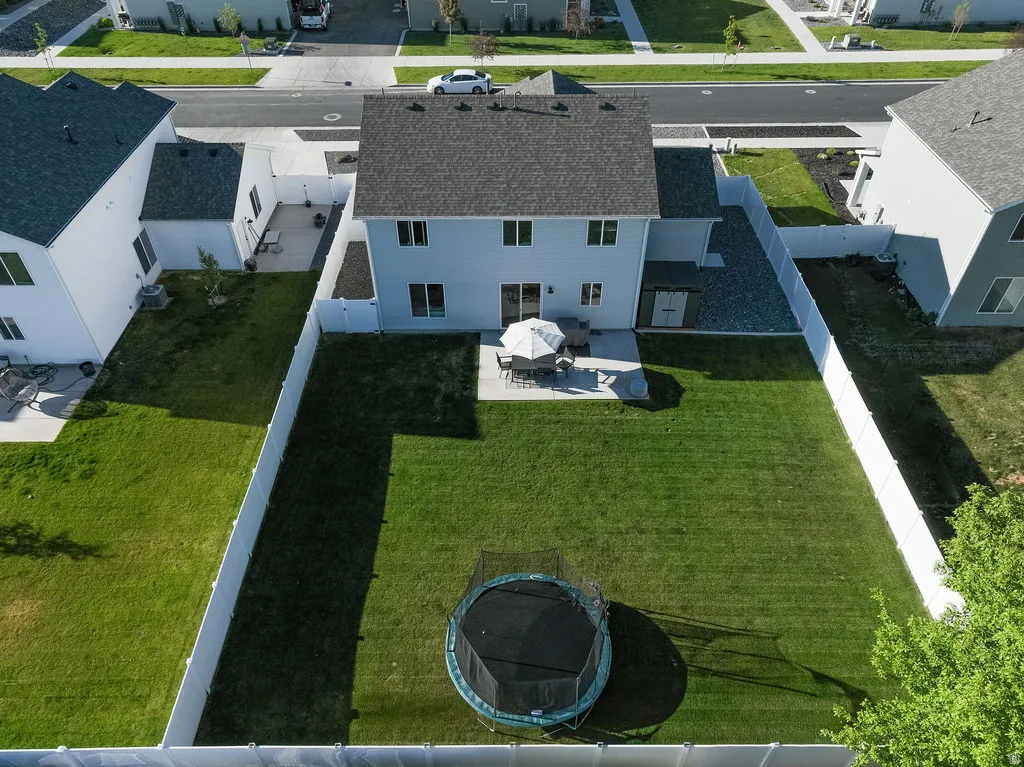 Expansive rear lawn framed by white vinyl fencing