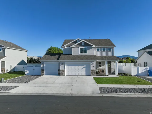 Contemporary two-story residence featuring light gray siding and stone accents