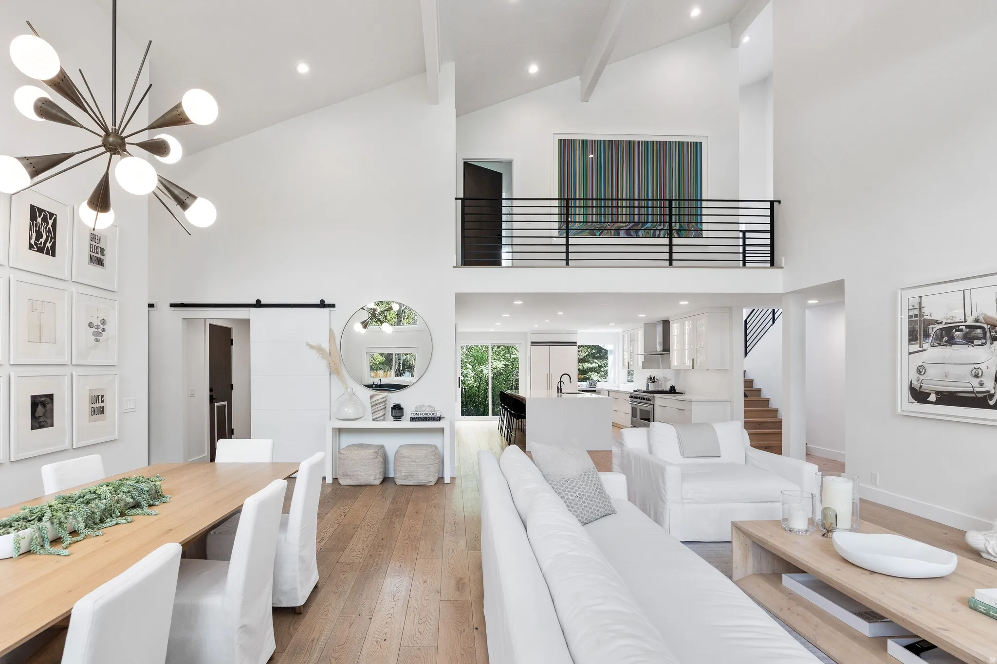 Vaulted ceilings with exposed beams complement the open-concept living space, featuring wood-finish flooring
