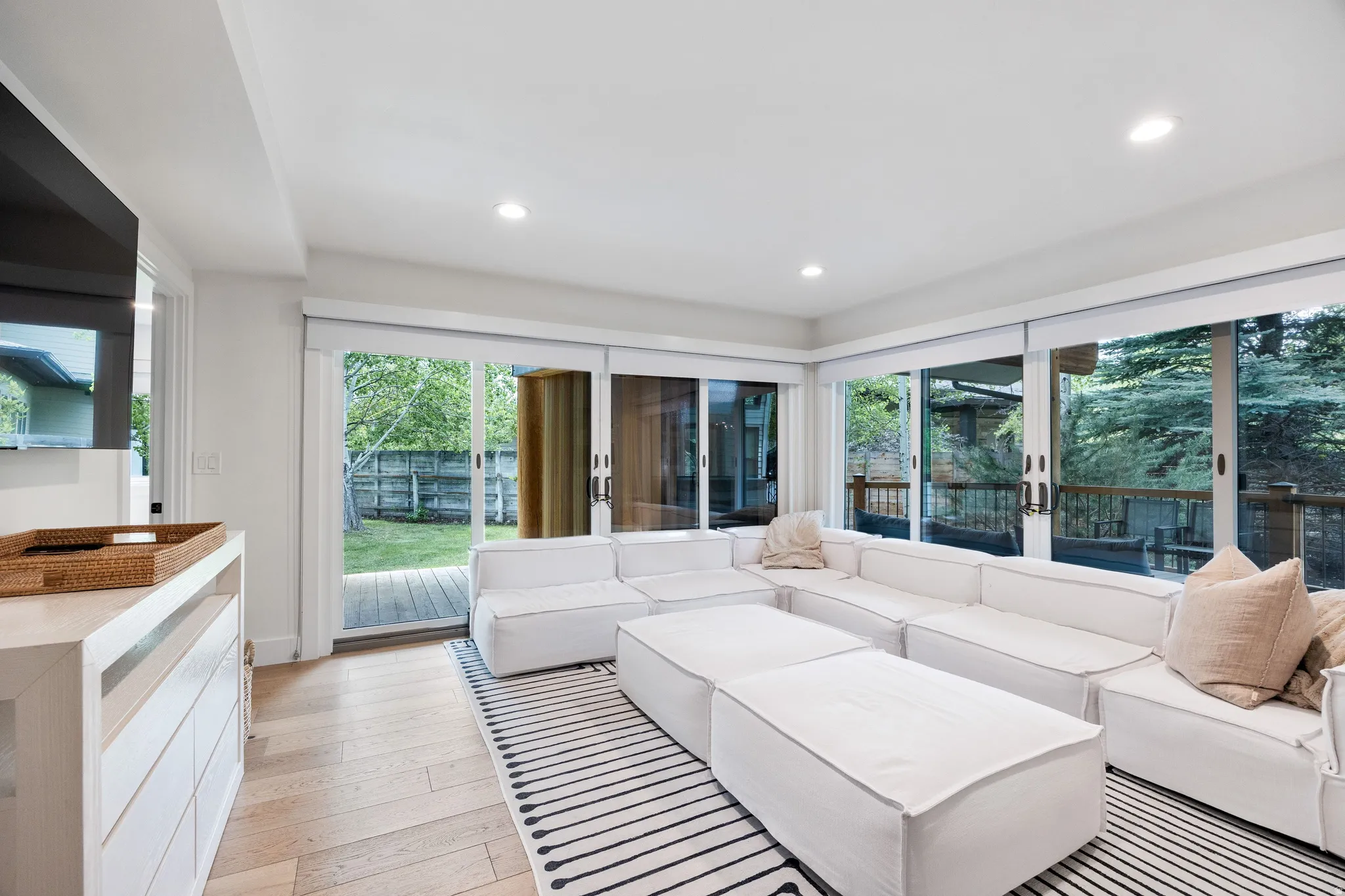 Living area featuring wood-finish flooring, recessed lighting, and expansive sliding glass doors