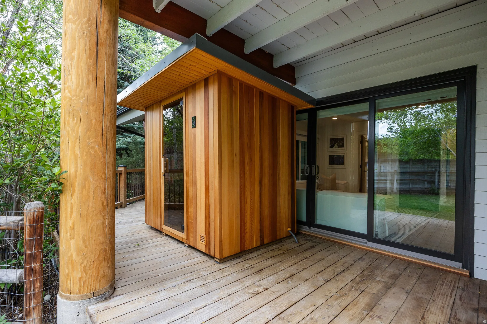 Exterior wood-clad sauna unit featuring a glass door