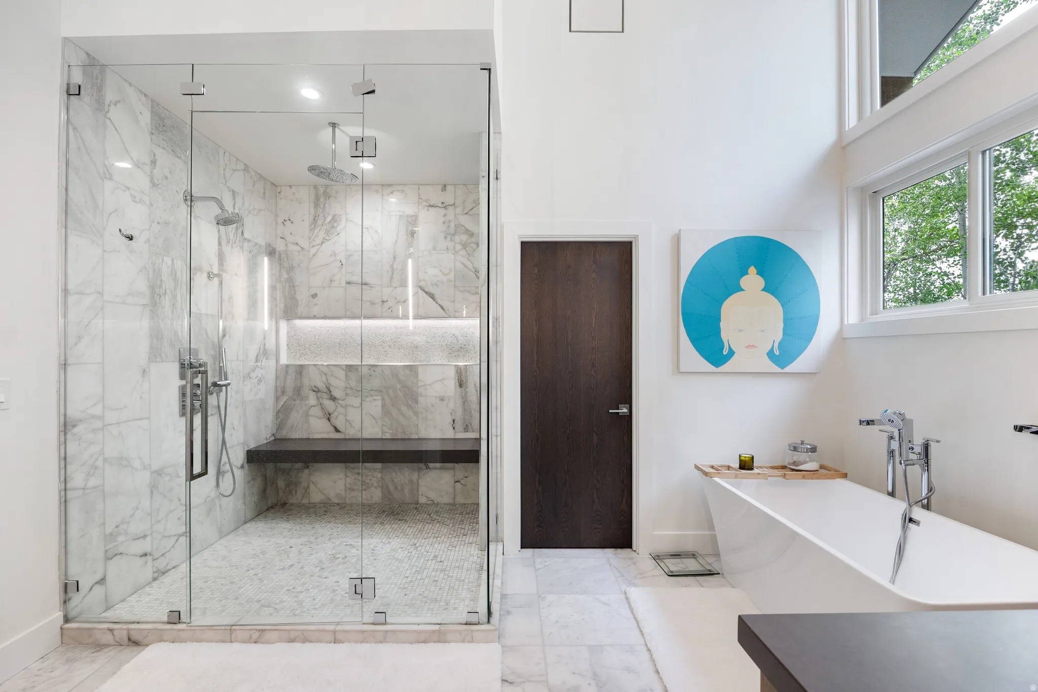 Spacious bathroom featuring a glass-enclosed shower with full-height stone-finish tiling and a built-in bench