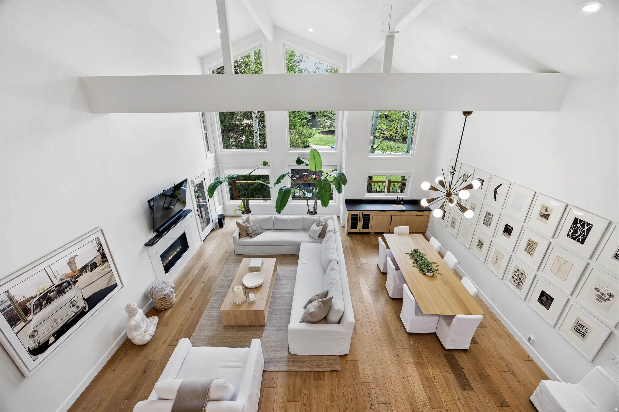 Open-concept living space featuring vaulted ceilings, a contemporary fireplace, and wood-finish flooring throughout