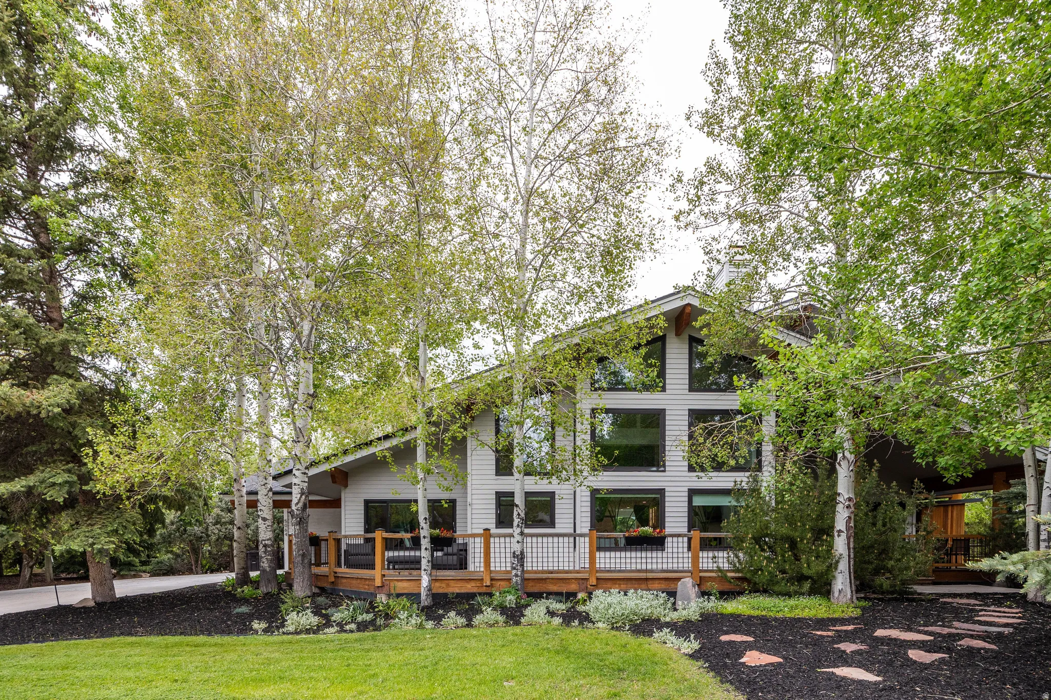 Contemporary-style residence featuring a prominent gabled roofline and light-colored siding