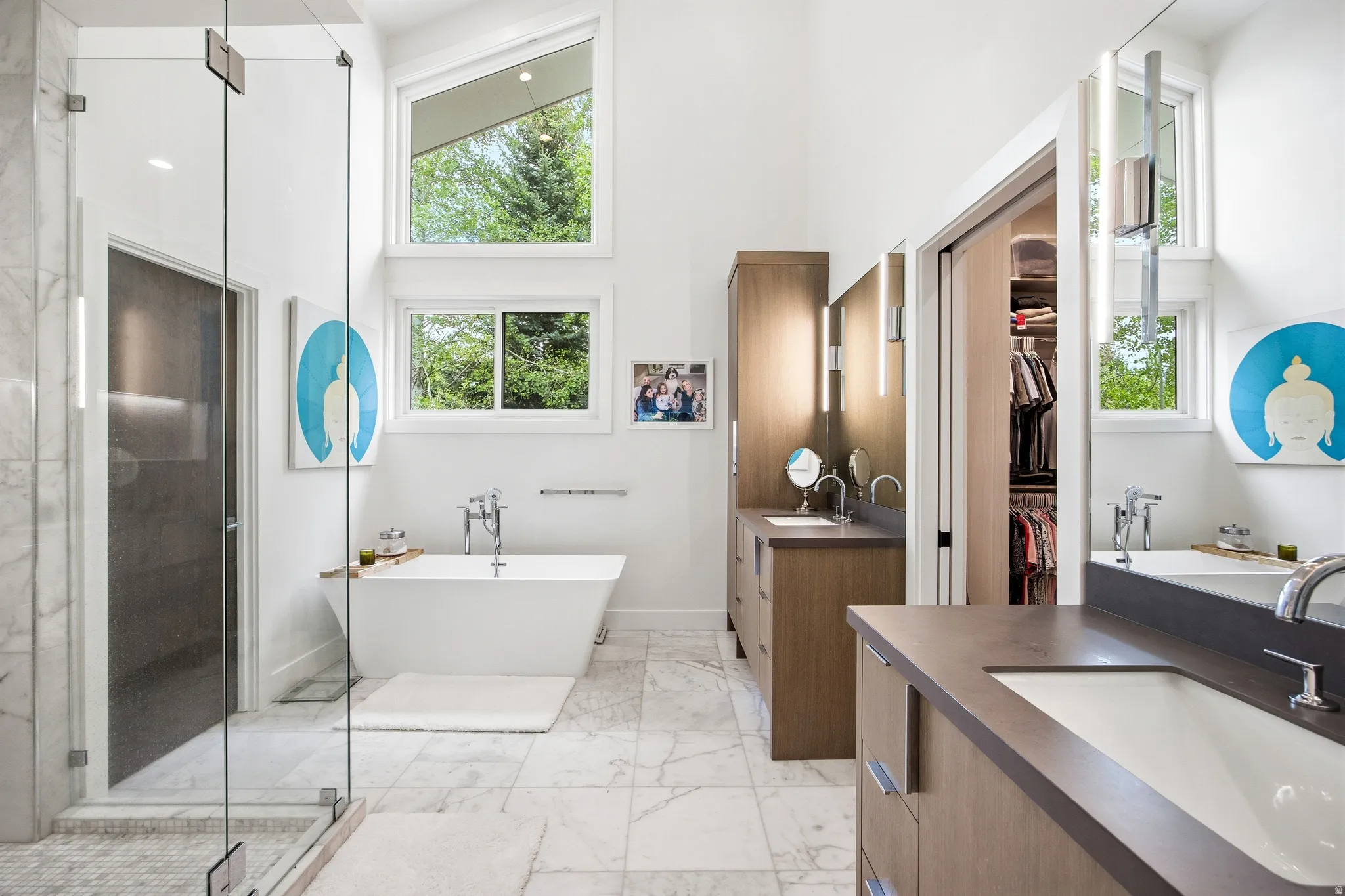 Spacious bathroom featuring a freestanding soaking tub, dual vanity with undermount sinks, and a glass-enclosed shower