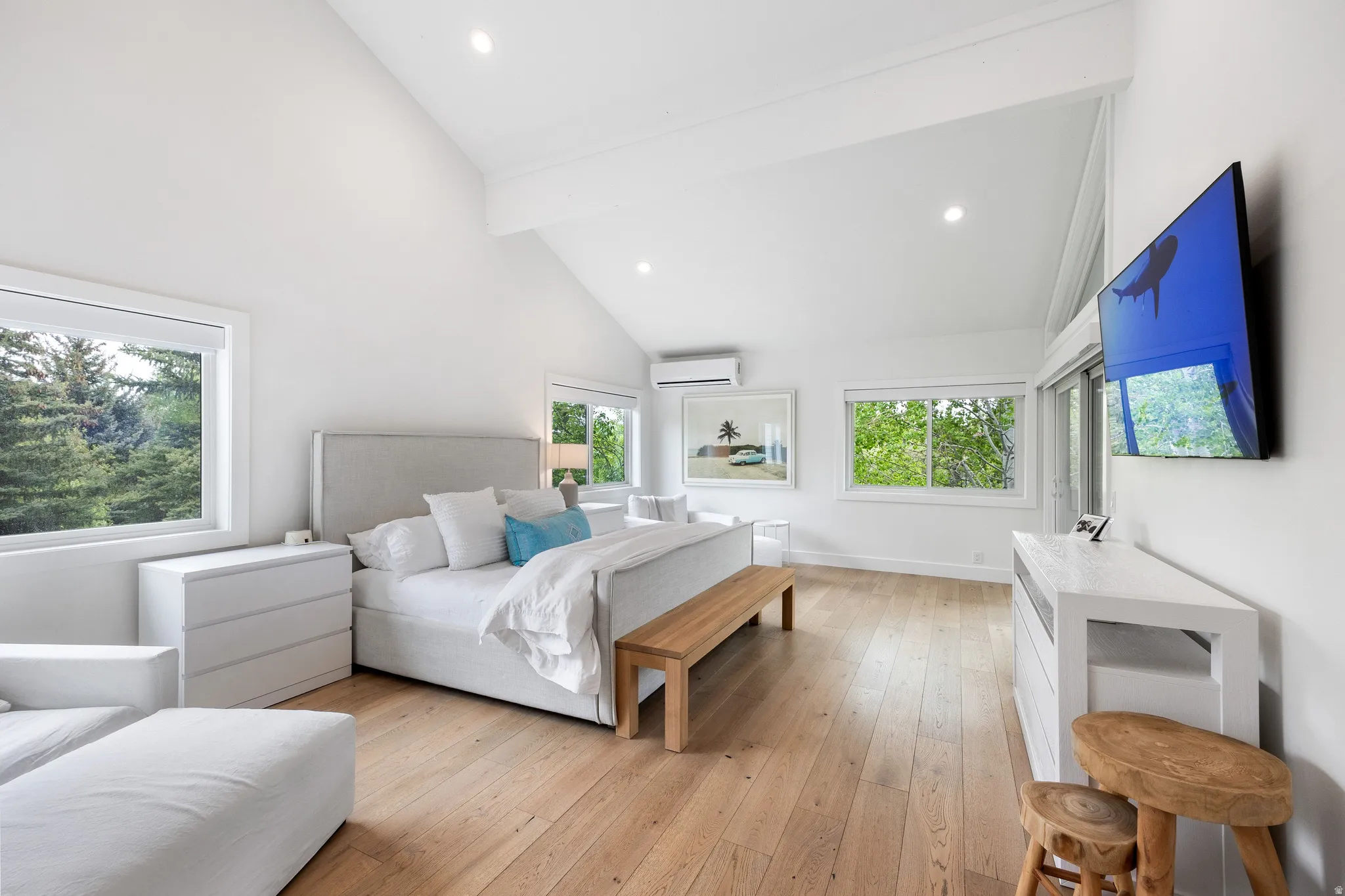 Vaulted ceilings with exposed beams complement the light wood-finish flooring
