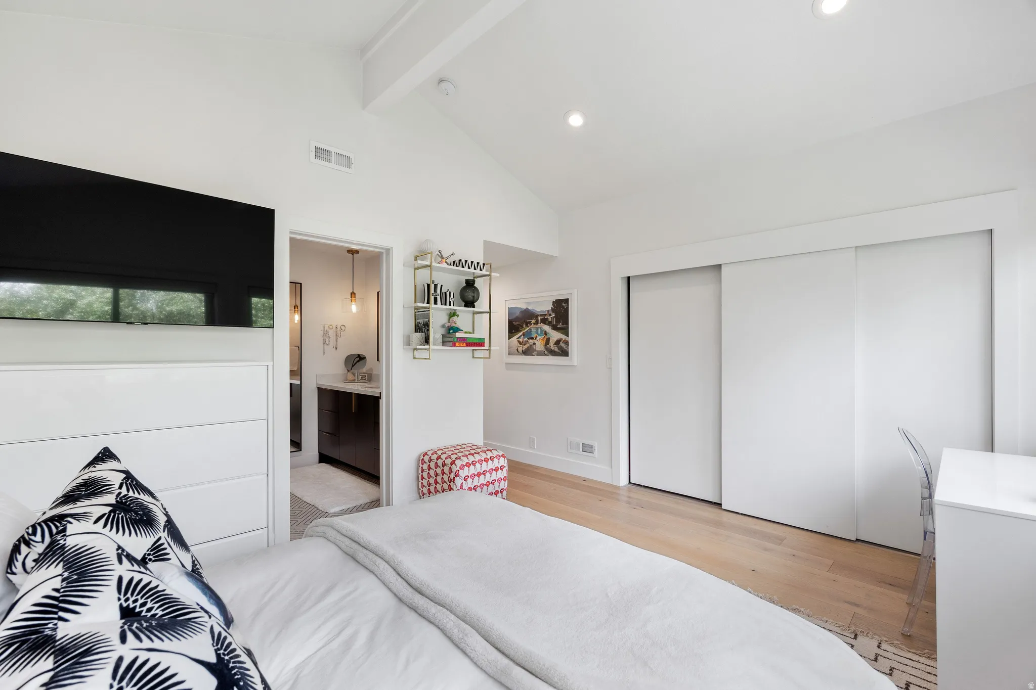 Bedroom featuring vaulted ceilings with exposed beam, light wood-finish flooring, recessed lighting, and sliding closet doors