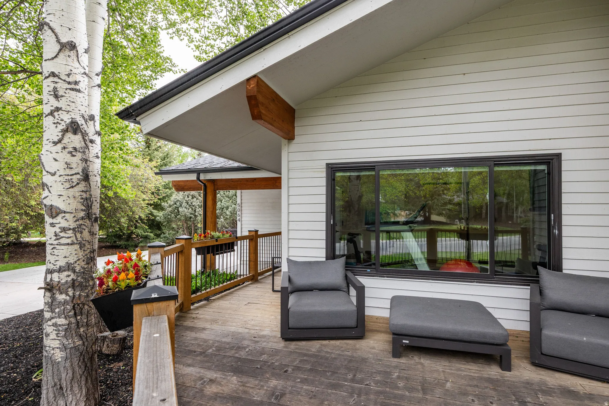 Expansive outdoor deck featuring wood-finish flooring and a wood railing with black spindles