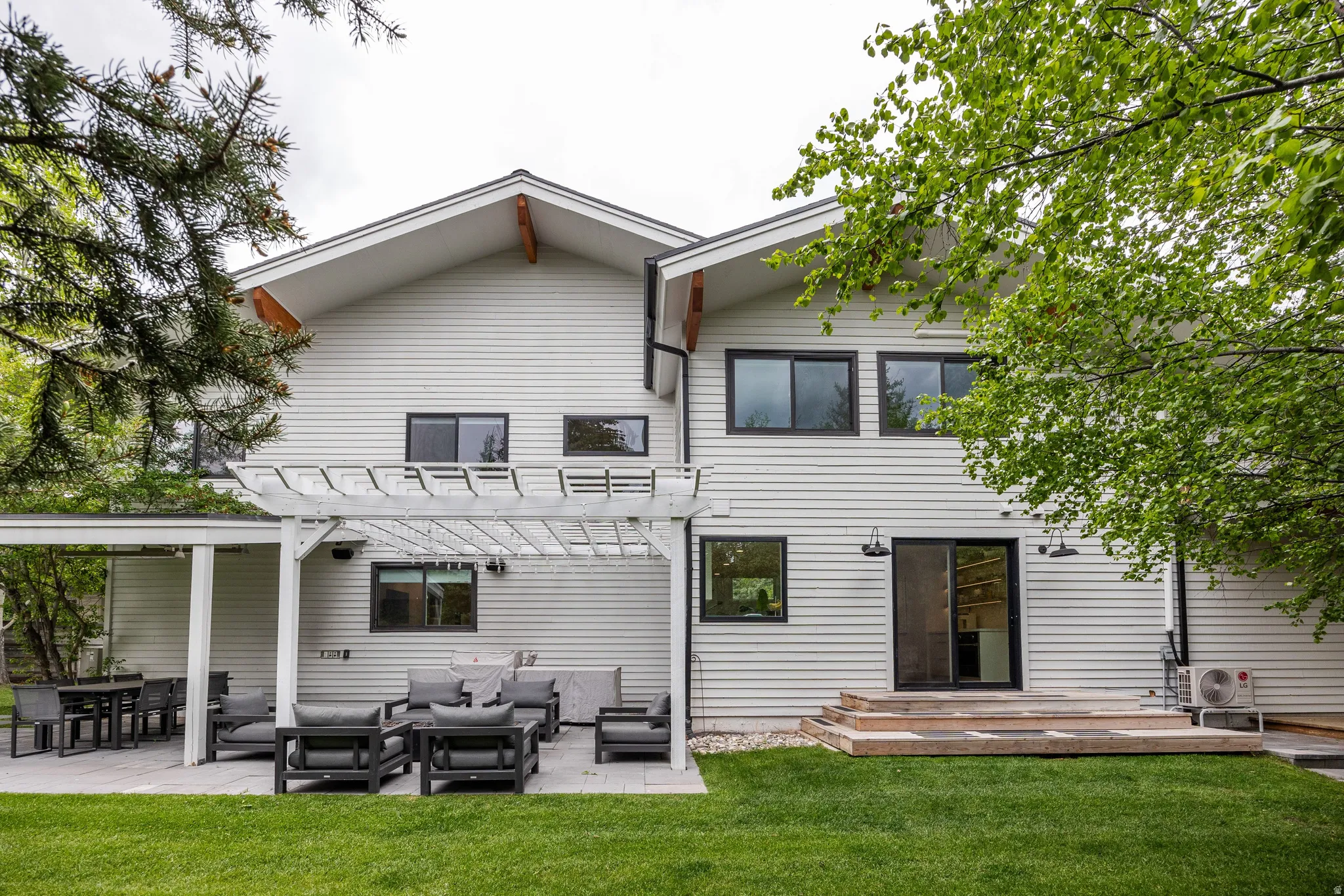 Modern exterior featuring light-colored horizontal siding and a gabled roofline with exposed wood architectural elements