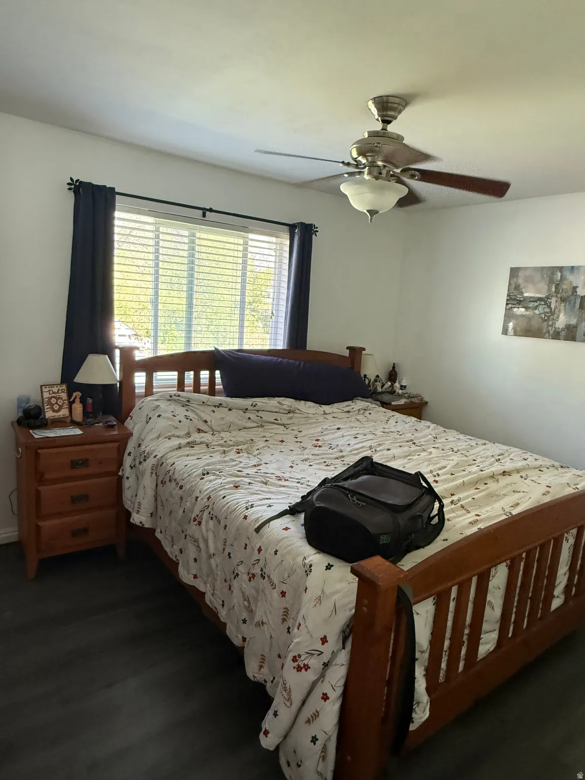Bedroom featuring wood-finish flooring, a window with blinds, and a ceiling fan with integrated lighting